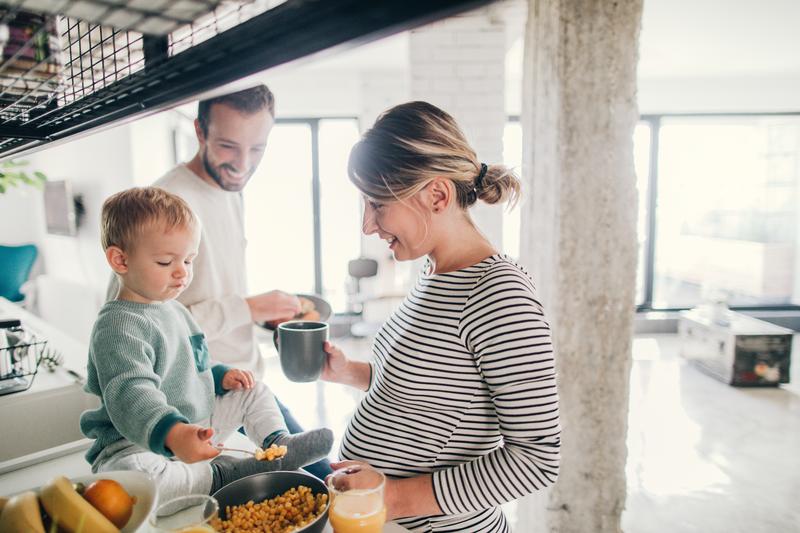 pregnant couple in kitchen with child.