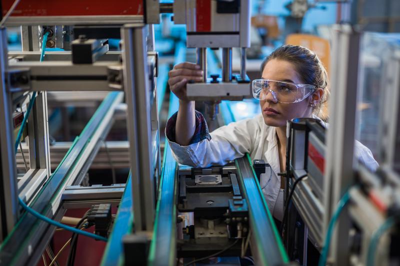 woman analyzing machine in lab