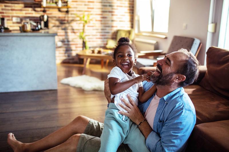 Father and daughter playing on the living room floor