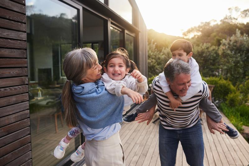 laughing grandchildren being carried outside by their grandparents in summer