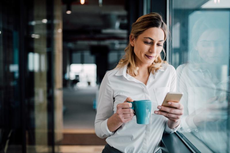 businesswoman texting during a coffee break