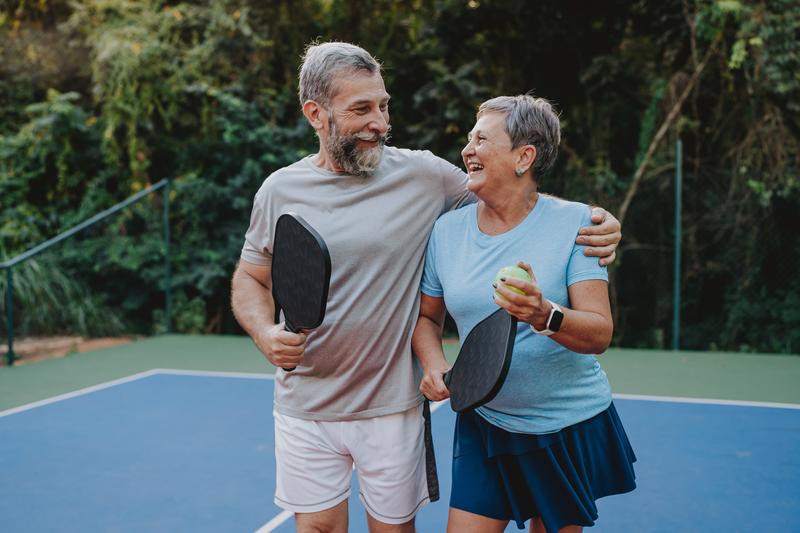 Image: senior couple playing pickleball.