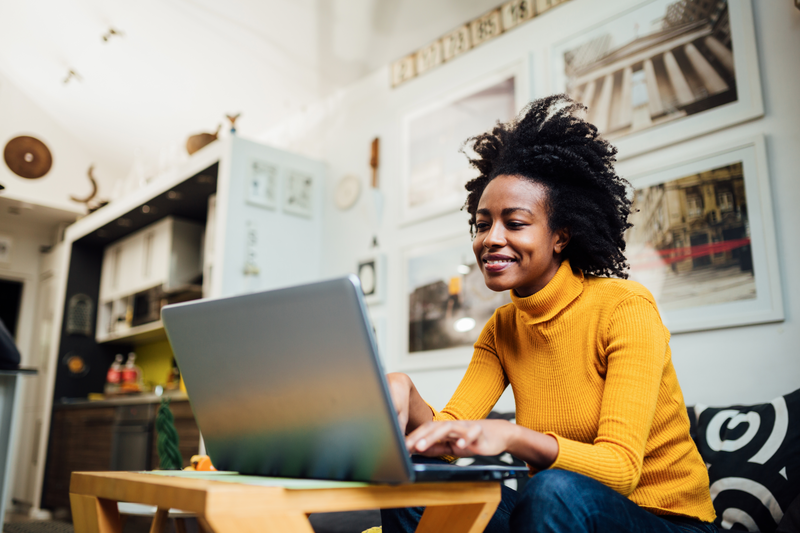 Image-woman-sitting-on-couch-working-on-laptop