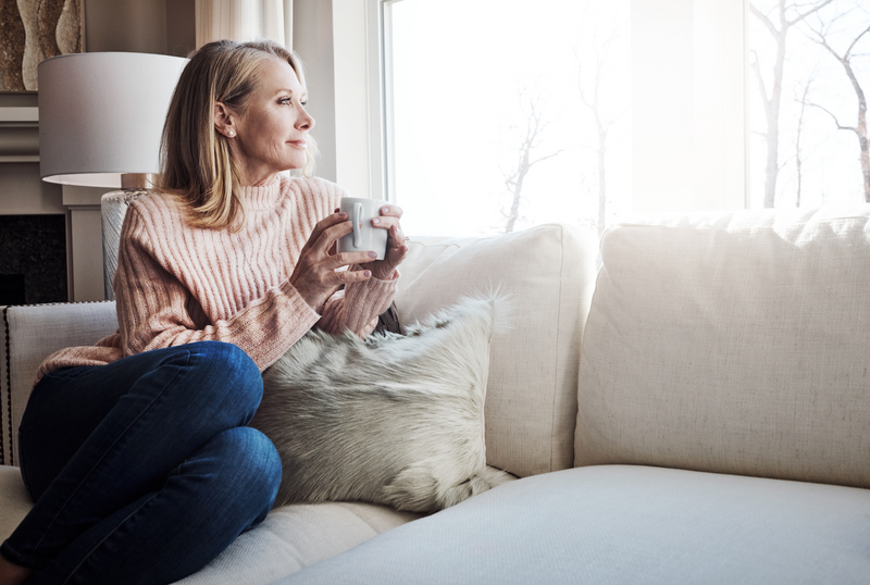 Woman sitting on a couch with coffee