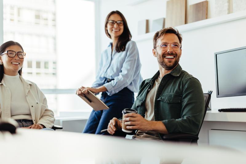 businesspeople smiling during discussion at meeting in office.