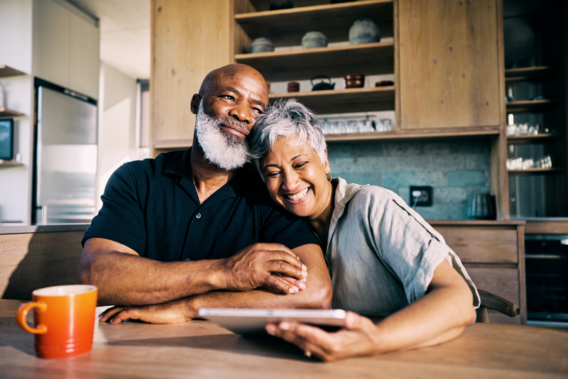 senior African-American couple smiling at kitchen table