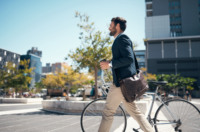 Man walking next to his bike on his way to work