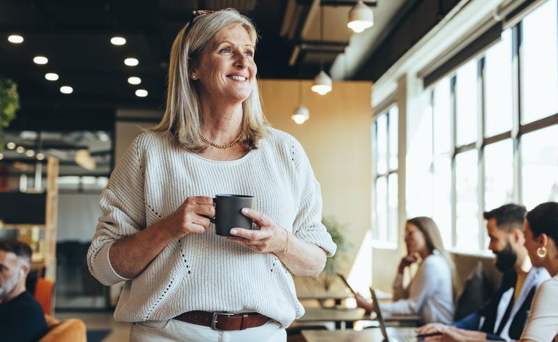 woman standing holding coffee cup.