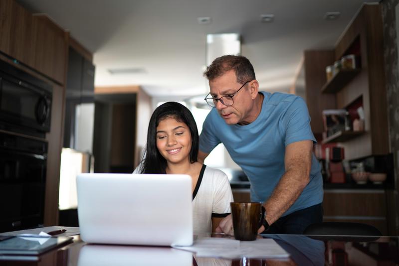father and daughter looking at laptop screen.