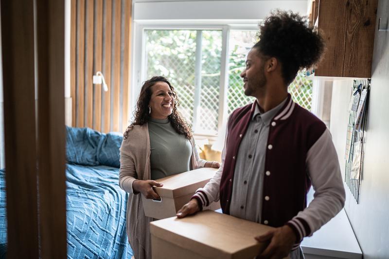 Image: mother helping son carrying moving boxes to move out from parent's home.