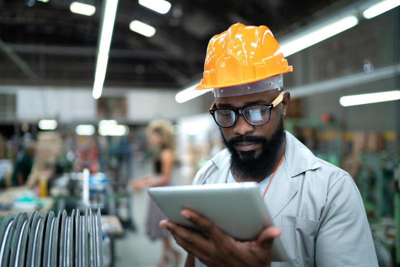 Image: man in hard hat in industrial setting.