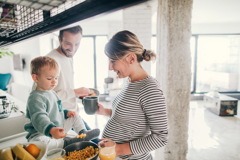 pregnant couple in kitchen with child