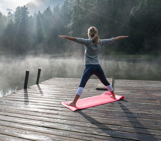 woman in yoga pose on dock.